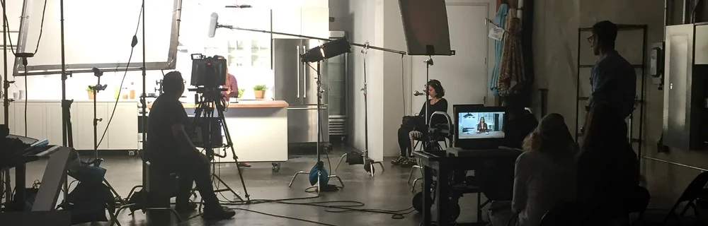 A crew filming a commercial on a kitchen set